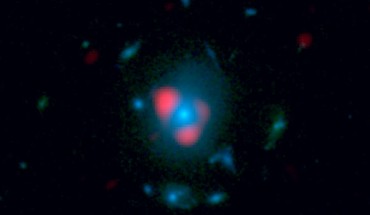 This image combines data from ALMA and Hubble. Shown in red is the distant, background galaxy, being distorted by the gravitational lens effect produced by the galaxy in the foreground, shown in blue as measured by Hubble. The background galaxy appears warped into a so-called Einstein ring: a circle of light around the foreground galaxy (Dan Marrone)