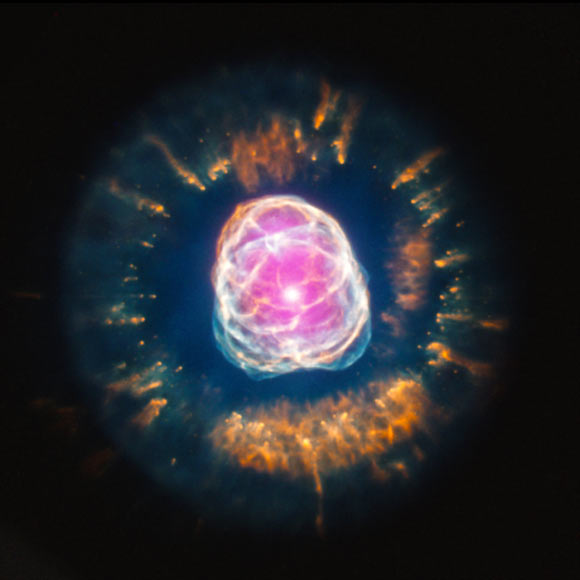 This image combines data from two different observatories: Chandra X-ray data – purple; Hubble data - red, green, and blue. X-ray data from Chandra reveal the location of million-degree gas near the center of the planetary nebula. Hubble data show the intricate pattern of the outer layers of the star that have been ejected (X-ray: NASA / CXC / IAA-CSIC / N. Ruiz et al; optical: NASA / STScI)
