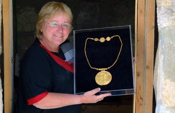 Dr Eilat Mazar displays a gold medallion found at the foot of Temple Mount. Image credit: Ouria Tadmor.