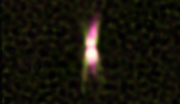 This image shows a jet of energetic particles emitting radio waves, shown in pink, coming from the star IRAS 15445-5449. Dusty material around the star, shown in green, was imaged with ESO's VLT Interferometer. The star itself is hidden by dust. Image credit: A. Pérez-Sánchez /ATCA / CSIRO / E. Lagadec / ESO.