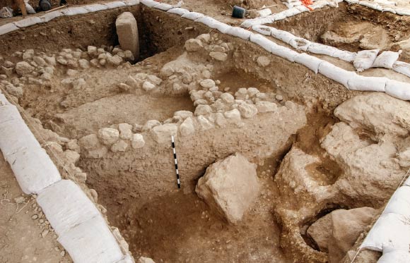 A 6,000-year-old building and the mazzeva. Image credit: Assaf Peretz / Israel Antiquities Authority.