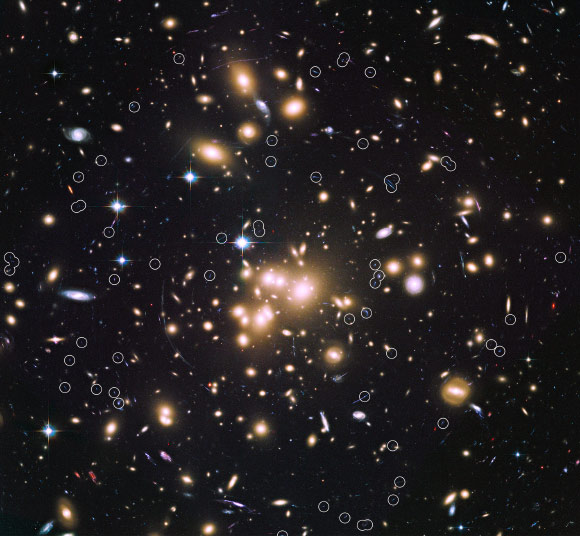 This image, taken with the Hubble Space Telescope, shows the giant galaxy cluster Abell 1689 and the newly discovered galaxies, circled. Image credit: NASA / ESA / B. Siana and A. Alavi, University of California, Riverside.