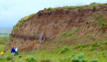 An eroding bluff on the U.S. Great Plains reveals a buried, carbon-rich layer of fossil soil. Image credit: Jospeh Mason.