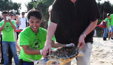 Yao Ming and Frederick Yeh release an endangered sea turtle back to nature. Image credit: Sea Turtles 911.