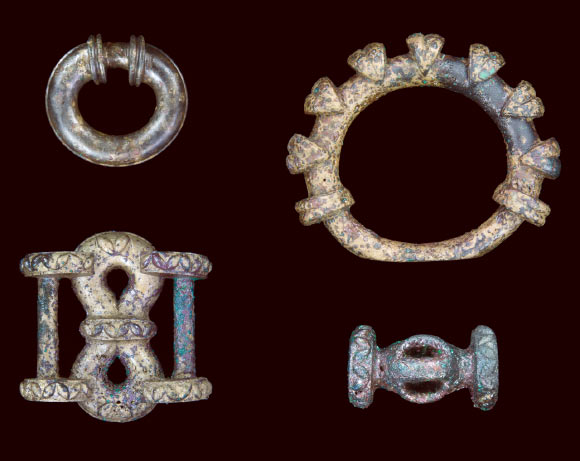 Selection of chariot fittings: miniature terret ring (upper left), large terret ring (upper right), strap junction (lower left) and barrel-shaped harness fitting. Image credit: University of Leicester.