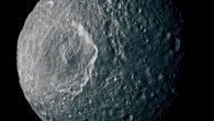 Mimas' surface, like the surfaces of most of the other major Saturnian moons without atmospheres, is not pure ice but contains some dark impurities; the relatively dark markings appear along the lower portion of the walls of the 130-km-wide Herschel Crater (the peak in the middle of the crater is about as tall as Mount Everest; the impact that made it likely almost destroyed the moon) and some of the smaller craters; scientists interpret this darkening as evidence for the gradual concentration of impurities from evaporating icy materials in areas where the dark impurities slide slowly down the crater wall. Image credit: NASA / JPL / Space Science Institute.