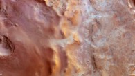 Hellas Chaos stretches roughly 200 km north–south and for about 500 km in an east–west direction. It shows a variety of landforms, from large impact craters containing wind-blown dunes or flat-topped mesas, to ridges and troughs with rough knobs of material protruding from the surface. The region is also dusted with carbon dioxide frost. North is to the right and west is at the top. The image was captured by Mars Express on 23 January 2014. Image credit: ESA / DLR / FU Berlin.