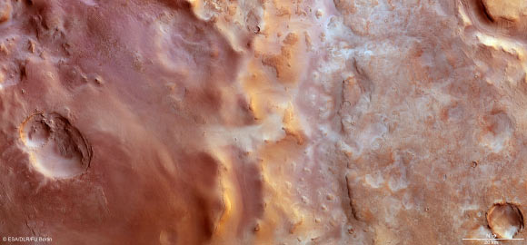 Hellas Chaos stretches roughly 200 km north–south and for about 500 km in an east–west direction. It shows a variety of landforms, from large impact craters containing wind-blown dunes or flat-topped mesas, to ridges and troughs with rough knobs of material protruding from the surface. The region is also dusted with carbon dioxide frost. North is to the right and west is at the top. The image was captured by Mars Express on 23 January 2014. Image credit: ESA / DLR / FU Berlin.