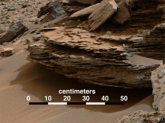 This view from the Mast Camera on board Curiosity shows an example of cross-bedding from water passing over a loose bed of sediment. The cross-bedding - evident as layers at angles to each other - reflects formation and passage of waves of sand, one on top of the other. These are known as ripples, or dunes. The direction of migration of these small ripples and dunes was toward the southeast. That direction is toward Mount Sharp and away from the area where Curiosity found evidence of delta deposits where a stream entered a lake. The directional flows recorded in the sediments are interpreted to have formed by currents moving down the deltas and into deeper lake water. The color has been approximately white-balanced to resemble how the scene would appear under daytime lighting conditions on Earth. Image credit: NASA / JPL-Caltech / MSSS.