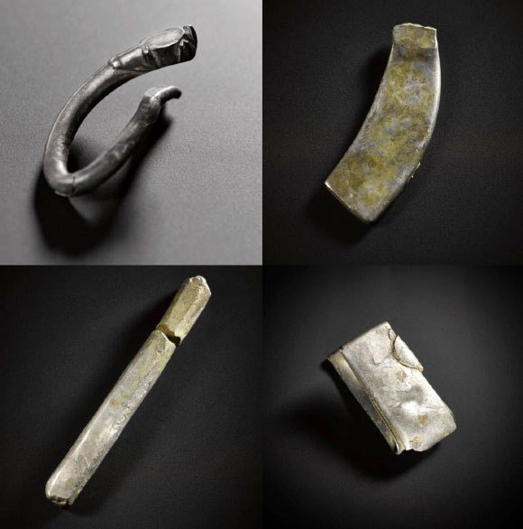 Silver objects from the Aberdeenshire hoard, from left to right, top to bottom: fragment of a zoomorphic silver brooch, an undecorated brooch, silver ingot, and a folded bracelet. Image credit: © National Museum Scotland.