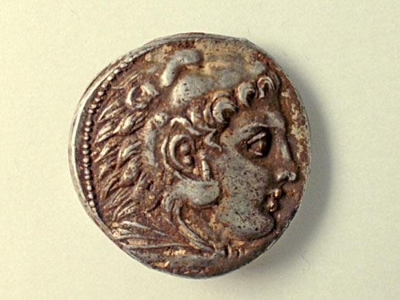 Obverse of a silver coin found at the site: Heracles' head right, clad in Nemean lion scalp headdress tied at neck. Image credit: Robert Kool / Israel Antiquities Authority.