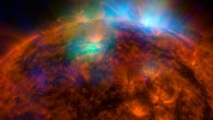 X-rays stream off the Sun in this image. The NuSTAR data, seen in green and blue, reveal solar high-energy emission (green shows energies between 2 and 3 kiloelectron volts, and blue shows energies between 3 and 5 kiloelectron volts). The high-energy X-rays come from gas heated to above 3 million degrees. The red channel represents UV light captured by SDO at wavelengths of 171 angstroms, and shows the presence of lower-temperature material in the solar atmosphere at 1 million degrees. This image shows that some of the hotter emission tracked by NuSTAR is coming from different locations in the active regions and the coronal loops than the cooler emission shown in the SDO image. Image credit: NASA / JPL-Caltech / GSFC.