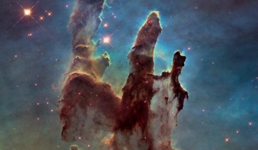 This image shows the Eagle Nebula’s Pillars of Creation as seen in visible light, capturing the multi-colored glow of gas clouds, wispy tendrils of dark cosmic dust, and the rust-colored elephants’ trunks of the nebula’s famous pillars. The dust and gas in the pillars is seared by the intense radiation from young stars and eroded by strong winds from massive nearby stars. Image credit: NASA / ESA / Hubble / Hubble Heritage Team.