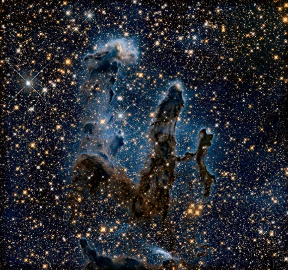This image shows the Pillars of Creation in infrared light, allowing it to pierce through obscuring dust and gas and unveil a more unfamiliar view of the object. In this ethereal view the entire frame is peppered with bright stars and baby stars are revealed being formed within the pillars themselves. The ghostly outlines of the pillars seem much more delicate, and are silhouetted against an eerie blue haze. Image credit: NASA / ESA / Hubble / Hubble Heritage Team.