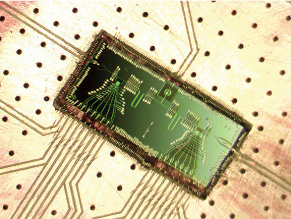This micromaser is a major step toward building quantum-computing systems out of semiconductor materials; a battery forces electrons to tunnel one by one through two double quantum dots located at each end of a cavity, moving from a higher energy level to a lower energy level and in the process giving off microwaves that build into a coherent beam of light. Image credit: Jason Petta.
