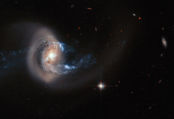 This image, taken with the Wide Field Camera 3 and the Advanced Camera for Surveys on Hubble, reveals the correlation of the gas clouds and stars in NGC 7714. The picture not only reveals the intricate structure of the galaxy, but also shows many other objects that are much further away. Image credit: NASA / ESA / A. Gal-Yam, Weizmann Institute of Science.