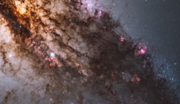 Resembling looming rain clouds on a stormy day, dark lanes of dust crisscross the giant elliptical galaxy NGC 5128, also known as Centaurus A. The warped shape of NGC 5128’s disk of gas and dust is evidence for a past collision and merger with another galaxy. The resulting shockwaves cause hydrogen gas clouds to compress, triggering a firestorm of new star formation. At a distance of just over 11 million light-years, NGC 5128 contains the closest active galactic nucleus to Earth. The center is home for a supermassive black hole that ejects jets of high-speed gas into space, but neither the supermassive black hole or the jets are visible in this image. Image credit: NASA / ESA / Hubble Heritage / STScI / AURA / Hubble Collaboration / R. O'Connell, University of Virginia / WFC3 Scientific Oversight Committee.