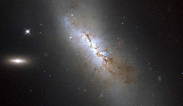 This image shows the barred spiral galaxy NGC 4424. To the left there are two bright objects in the frame: the brightest is another, smaller galaxy known as LEDA 213994, and the object closer to NGC 4424 is an anonymous star in our Milky Way Galaxy. Image credit: ESA / Hubble / NASA / Gilles Chapdelaine.