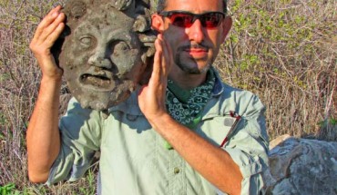 University of Haifa archaeologist with the bronze mask of Pan. Image credit: Michael Eisenberg.