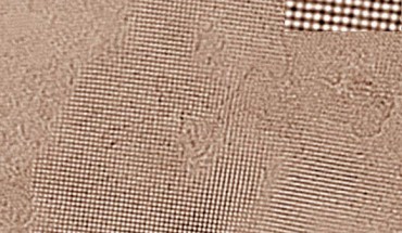 Square ice between two graphene sheets as seen in a transmission electron microscope (TEM); high-contrast dark spots are oxygen atoms that indicate positions of water molecules; hydrogen atoms yield too little contrast to be resolved even by the TEM. The top right inset shows a magnified image of a small area in the centre of the ice crystal. Image credit: University of Ulm.