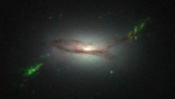 This Hubble image shows ghostly green filaments, lying within galaxy 2MASX J22014163+1151237. This filament was illuminated by a blast of radiation from a quasar - a very luminous and compact region that surrounds the supermassive black hole at the center of its host galaxy. Its bright green hue is a result of ionized oxygen, which glows brightly at green wavelengths. Image credit: NASA / ESA / W. Keel, University of Alabama.