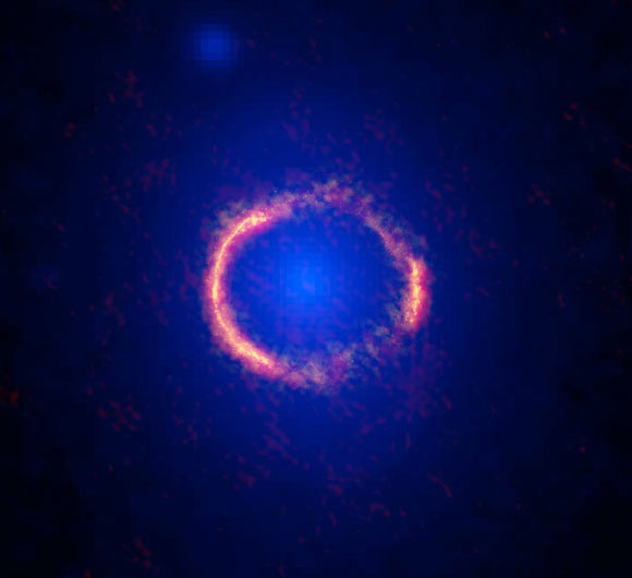 This composite image shows the gravitationally lensed galaxy SDP.81; the bright orange central region of the ring reveals the glowing dust in this distant galaxy; the surrounding lower-resolution portions of the ring trace the millimeter wavelength light emitted by carbon monoxide; the diffuse blue element at the center of the ring is from the intervening lensing galaxy. Image credit: ALMA / NRAO / ESO / NAOJ / B. Saxton / AUI / NSF / NASA / ESA / Hubble / T. Hunter.