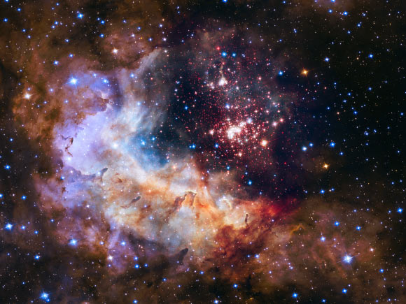 This image of the open star cluster Westerlund 2 and its surroundings has been released to celebrate Hubble’s 25th year in orbit. The image’s central region, containing the star cluster, blends visible-light data taken by the Advanced Camera for Surveys and near-infrared exposures taken by the Wide Field Camera 3. The surrounding region is composed of visible-light observations taken by the Advanced Camera for Surveys. Image credit: NASA / ESA / Hubble Heritage Team / STScI / AURA / A. Nota / Westerlund 2 Science Team.