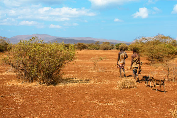 Two Hadza men return from a hunt. The Hadza people are one of the last hunter-gatherer tribes left in Africa. Image credit: Andreas Lederer / CC BY 2.0.