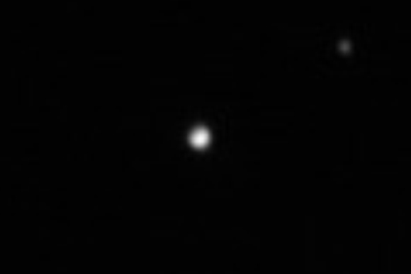 This image, taken May 13, 2015, shows the dwarf planet Pluto and its moon Charon. Image credit: NASA / JHU-APL / SwRI.