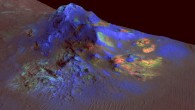 Deposits of impact glass have been preserved in Martian craters, including Alga Crater, shown here. In color coding based on analysis of data from the CRISM instrument on NASA’s Mars Reconnaissance Orbiter, green indicates the presence of glass; blues are pyroxene; reds are olivine. This view shows Alga Crater’s central peak, which is about 3 miles (5 km) wide within the 12-mile (19-km) diameter of this southern-hemisphere crater. The information from CRISM is shown over a terrain model and image based on observations by the High Resolution Imaging Science Experiment (HiRISE) camera. The vertical dimension is exaggerated by a factor of two. Image credit: NASA / JPL-Caltech / JHUAPL / University of Arizona.