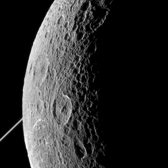 This image was taken in visible light with the Cassini spacecraft narrow-angle camera on June 16, 2015. The bright rings of Saturn can be seen at left. North on Dione is up and rotated 44 degrees to the left. Image credit: NASA / JPL-Caltech / Space Science Institute.