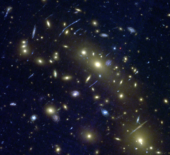 This Hubble image shows the cluster of galaxies MACS0416.1-2403. Bright yellow ‘elliptical’ galaxies can be seen, surrounded by numerous blue spiral and amorphous galaxies. Gravitational arcs can also be seen. This image forms the test data that the machine learning algorithm is applied to, having not previously seen the image. Image credit: NASA / ESA / J. Geach / A. Hocking.