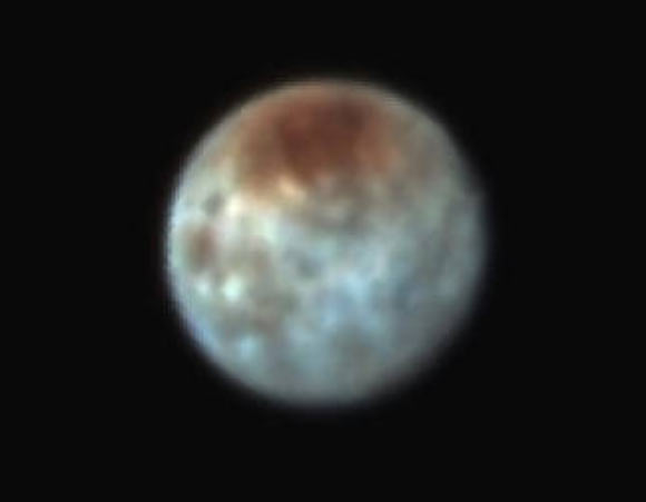 This false-color image shows Pluto’s largest moon, Charon. The red on the dark northern polar cap of Charon is attributed to hydrocarbon materials including a class of chemical compounds called tholins. The mottled colors at lower latitudes point to the diversity of terrains on Charon. Image credit: NASA / Johns Hopkins University Applied Physics Laboratory / Southwest Research Institute.