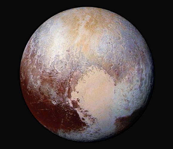 Four images from New Horizons’ Long Range Reconnaissance Imager were combined with color data from the Ralph instrument to create this enhanced color global view of Pluto. The images were taken when the spacecraft was 280,000 miles (450,000 km) away. Pluto’s Sputnik Planum is suggestive of a source region of ices. The two bluish-white ‘lobes’ that extend to the southwest and northeast of the ‘heart’ may represent exotic ices being transported away from Sputnik Planum. Image credit: NASA / Johns Hopkins University Applied Physics Laboratory / Southwest Research Institute.