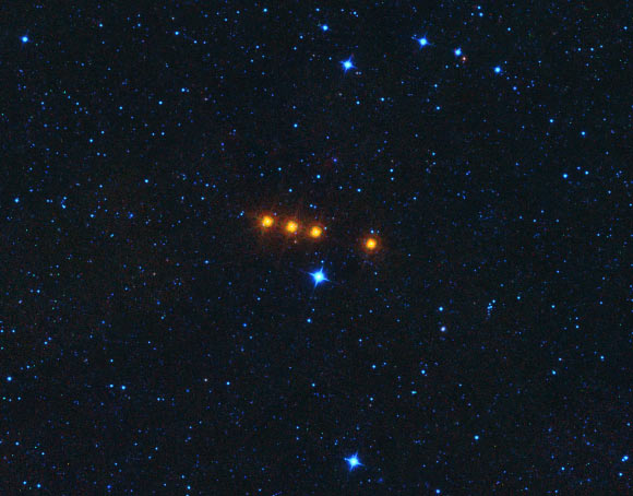 The asteroid 31 Euphrosyne glides across a field of background stars in this time-lapse view from NASA’s WISE spacecraft. WISE obtained the images used to create this view over a period of about a day around May 17, 2010, during which it observed the asteroid four times. The moving asteroid appears as a string of orange dots because it is much cooler than the distant background stars. Stars have temperatures in the thousands of degrees, but the asteroid is cooler than room temperature. Thus the stars are represented by shorter wavelength blue colors in this view, while the asteroid is shown in longer wavelength reddish colors. Image credit: NASA / JPL-Caltech.