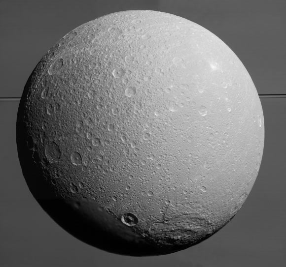 This view from Cassini looks toward Dione, with giant Saturn and its rings in the background, just prior to the mission’s final close approach to the moon on August 17. The view was acquired at distances ranging from approximately 106,000 miles (170,000 km) to 39,000 miles (63,000 km) from the icy moon and at a Sun-Dione-spacecraft, or phase, angle of 35 degrees. At lower right is the large, multi-ringed impact basin Evander, which is about 220 miles (350 km) wide. The canyons of Padua Chasma, features that form part of Dione’s bright, wispy terrain, reach into the darkness at left. Scientists combined nine visible light images to create this mosaic view: eight from Cassini’s narrow-angle camera and one from the wide-angle camera, which fills in an area at lower left. The scene is an orthographic projection centered on terrain at 0.2 degrees north latitude, 179 degrees west longitude on Dione. An orthographic view is most like the view seen by a distant observer looking through a telescope. North on Dione is up. Image credit: NASA / JPL-Caltech / Space Science Institute.