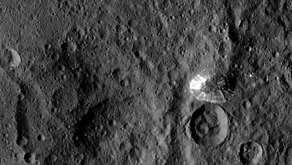 Dawn spotted this conical mountain on Ceres from a distance of 915 miles (1,470 km). The image was taken on August 19, 2015. The mountain, located in the southern hemisphere, stands 4 miles (6 km) high. Its perimeter is sharply defined, with almost no accumulated debris at the base of the brightly streaked slope. Image credit: NASA / JPL-Caltech / UCLA / MPS / DLR / IDA.