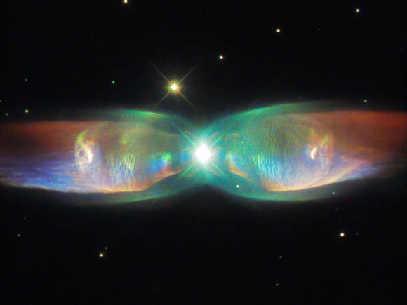 This Hubble image shows a bipolar planetary nebula named the Twin Jet Nebula, located about 5,560 light-years away in the constellation Ophiuchus. Bipolar planetary nebulae are formed when the central object is not a single star, but a binary system. Studies have shown that the nebula’s size increases with time, and measurements of this rate of increase suggest that the stellar outburst that formed the lobes occurred just 1,200 years ago. Image credit:  NASA / ESA / Hubble / Judy Schmidt.