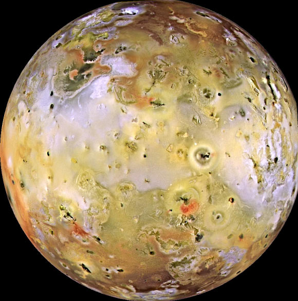 This image from NASA’s Galileo spacecraft shows Io. There are rugged mountains several miles high, layered materials forming plateaus, and many irregular depressions called volcanic calderas. Several of the dark, flow-like features correspond to hot spots, and may be active lava flows. There are no landforms resembling impact craters, as the volcanism covers the surface with new deposits much more rapidly than the flux of comets and asteroids can create large impact craters. The picture is centered on the side of Io that always faces away from Jupiter; north is to the top. Image credit: NASA / JPL / University of Arizona.