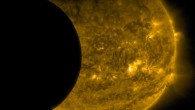 This image was taken by NASA’s Solar Dynamics Observatory at 3:12 a.m. EDT on September 13, 2015. The edge of Earth, visible near the top of the frame, appears fuzzy because Earth’s atmosphere blocks different amounts of light at different altitudes. On the left, the Moon’s edge is perfectly crisp, because it has no atmosphere. This image was taken in extreme UV wavelengths of 171 angstroms. Though this light is invisible to our eyes, it is typically colorized in gold. Image credit: NASA / SDO.