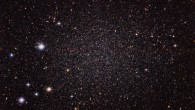 This image shows the Sculptor Dwarf Galaxy, a close neighbor of our own Milky Way Galaxy. Despite their proximity, both galaxies have very distinct histories and characters. This galaxy is much smaller, fainter and older than the Milky Way and appears here as a cloud of faint stars filling most of the image. Many other much more distant galaxies can be seen shining right through the sparse stars of the galaxy. Image credit: ESO.