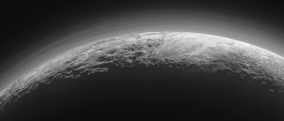 This panoramic image of Pluto highlights dwarf planet’s varied terrains and extended atmosphere. The scene measures 780 miles (1,250 km) across. The smooth expanse of Sputnik Planum (right) is flanked to the west (left) by rugged mountains up to 11,000 feet (3.5 km) high, including Norgay Montes in the foreground and Hillary Montes on the skyline. To the right, east of Sputnik, rougher terrain is cut by apparent glaciers. The backlighting highlights over a dozen layers of haze in the atmosphere of Pluto. The image was taken from a distance of 11,000 miles (18,000 km) to Pluto. Image credit: NASA / Johns Hopkins University Applied Physics Laboratory / Southwest Research Institute.