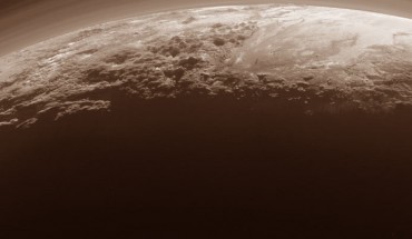 This panoramic image of Pluto highlights dwarf planet’s varied terrains and extended atmosphere. The scene measures 780 miles (1,250 km) across. The smooth expanse of Sputnik Planum (right) is flanked to the west (left) by rugged mountains up to 11,000 feet (3.5 km) high, including Norgay Montes in the foreground and Hillary Montes on the skyline. To the right, east of Sputnik, rougher terrain is cut by apparent glaciers. The backlighting highlights over a dozen layers of haze in the atmosphere of Pluto. The image was taken from a distance of 11,000 miles (18,000 km) to Pluto. Image credit: NASA / Johns Hopkins University Applied Physics Laboratory / Southwest Research Institute.