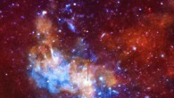 The upper two panels of this graphic represent a possible explanation for a recent increase in X-ray flares from Sagittarius A* seen by three X-ray telescopes. As part of a long monitoring campaign, astronomers observed the black hole as a mysterious object called G2 appeared to pass close to the black hole. The timing of G2’s passage could suggest that material from G2 caused the surge in X-ray activity, but it is also possible that this unrelated behavior of Sagittarius A*. The bottom panel is a view of the region around the black hole where red, green, and blue represent low, medium, and high-energy X-rays detected by NASA’s Chandra X-ray Observatory. Sagittarius A* itself is not visible in this image, but is embedded in the white dot at the end of the arrow. Image credit: NASA / CXC / MPE / G.Ponti et al. / M.Weiss.
