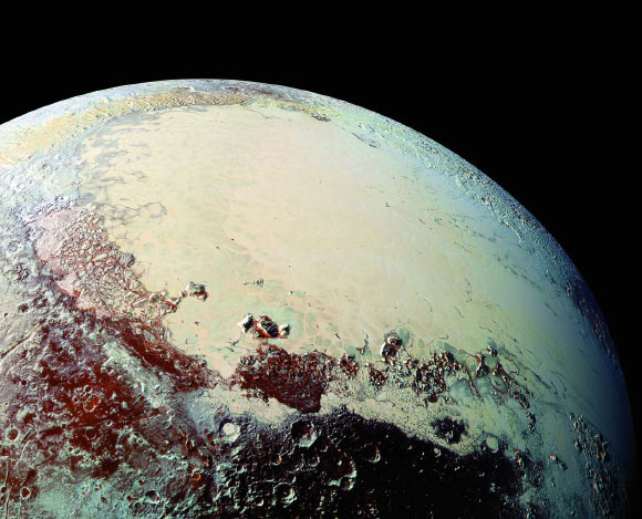 This Pluto mosaic was made from New Horizons LORRI images taken on July 14, 2015, from a distance of 49,700 miles (80,000 km). This view is projected from a point 1,118 miles (1,800 km) above Pluto’s equator, looking northeast over the dark, cratered Cthulhu Regio toward the bright, smooth expanse of icy plains called Sputnik Planum. Pluto’s North Pole is off the image to the left. This mosaic was produced with panchromatic images from the New Horizons LORRI camera, with color overlaid from the Ralph color mapper onboard New Horizons. Image credit: S.A. Stern et al, doi: 10.1126/science.aad1815.