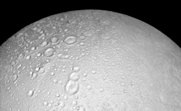This image from Cassini shows battered terrain around the north pole of Enceladus. Craters crowd and overlap each other, each one recording an impact in the moon’s distant past. The moon’s north pole lies approximately at the top of this image. North on Enceladus is up. The view was acquired at a distance of 4,000 miles (6,000 km) from Enceladus and at a Sun-Enceladus-spacecraft, or phase, angle of 8 degrees. Image credit: NASA / JPL-Caltech / Space Science Institute.