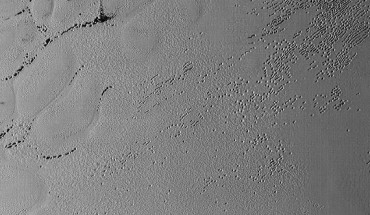 This image of Pluto’s surface was taken by NASA’s New Horizons spacecraft shortly before closest approach to the dwarf planet on July 14, 2015. The scene is about 130 miles (210 km) across. The Sun illuminates the scene from the left, and north is to the upper left. Image credit: NASA / Johns Hopkins University Applied Physics Laboratory / Southwest Research Institute.