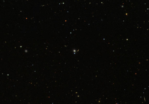 This is an optical image, based on data from the Sloan Digital Sky Survey, showing some galaxies that are part of the Coma Supercluster. The yellow blob at the center is PGC 43234, a small galaxy in which astronomers witnessed stellar debris being blown away after a supermassive black hole destroyed a star. With PGC 43234 located 290 million light-years away from us, it was the closest tidal disruption event to be discovered in the past decade. Studying it with X-ray telescopes, the astronomers could measure, for the first time, the physical properties of a newly formed accretion disc around a black hole. Image credit: Sloan Digital Sky Survey.