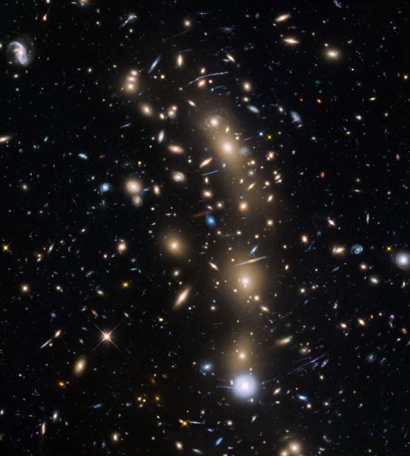 This Hubble image shows the galaxy cluster MACS J0416.1–2403 (MACS0416). This is one of six being studied by the Hubble Frontier Fields program, which together have produced the deepest images of gravitational lensing ever made. Due to the huge mass of the cluster it is bending the light of background objects, acting as a magnifying lens. Image credit: NASA / ESA / HST Frontier Fields Team / STScI.