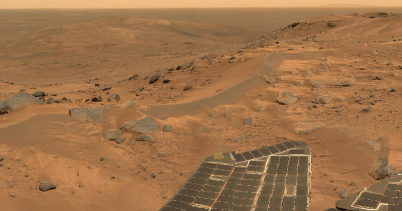 This mini-panorama was taken by NASA’s Spirit rover on August 23, 2005, just as the rover finally completed its intrepid climb up Husband Hill. The summit appears to be a windswept plateau of scattered rocks, little sand dunes and small exposures of outcrop.  The approximate true-color view spans about 90 degrees and consists of images obtained by the rover’s panoramic camera during 18 individual pointings. Image credit: NASA / JPL-Caltech / Cornell.